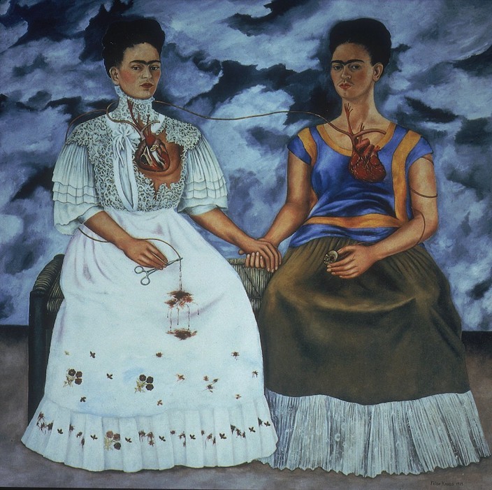 Painting of two versions of Frida Kahlo seated on a bench holding hands and with their hearts exposed.
